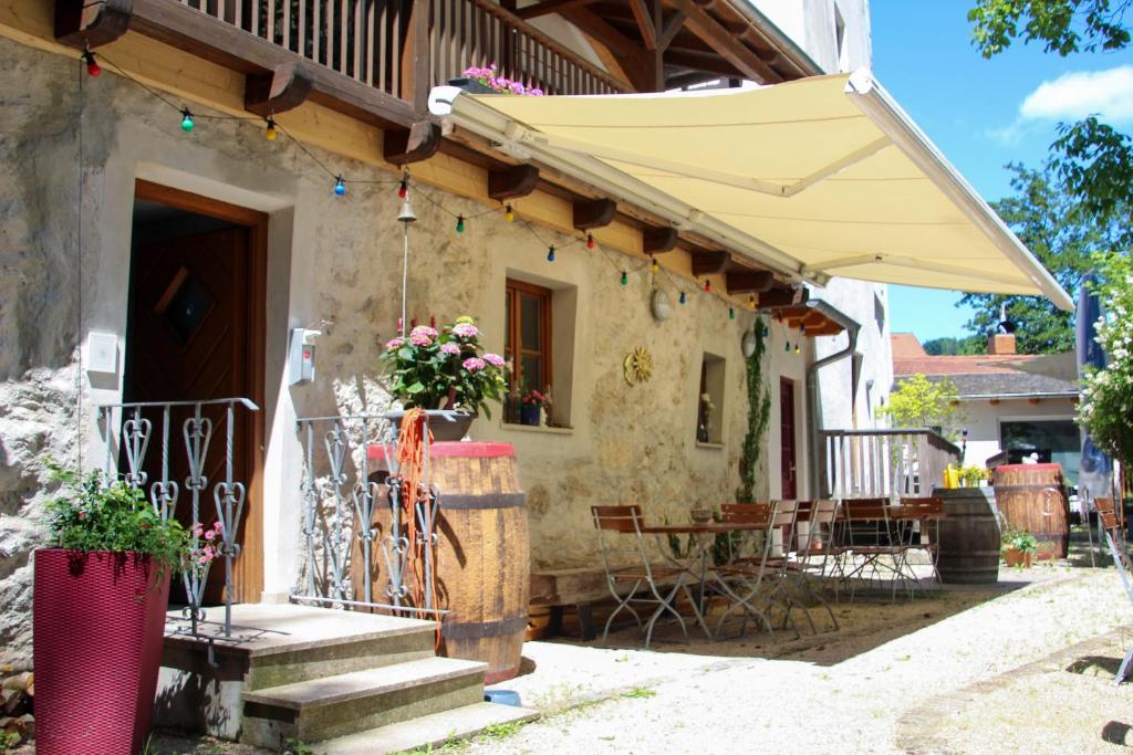 ein Haus mit einem Regenschirm, einem Tisch und Stühlen in der Unterkunft Turmhotel zum Erasmus in Kelheim