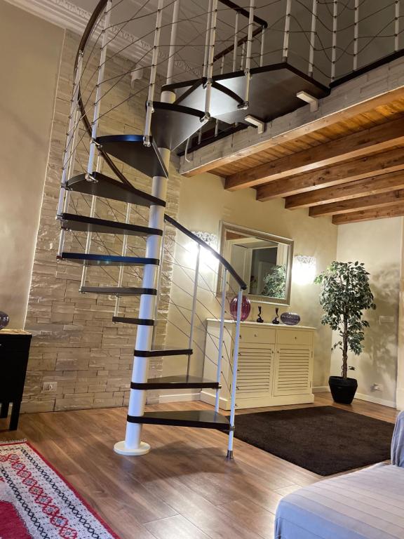 a spiral staircase in a room with a brick wall at Katanehouse in Catania