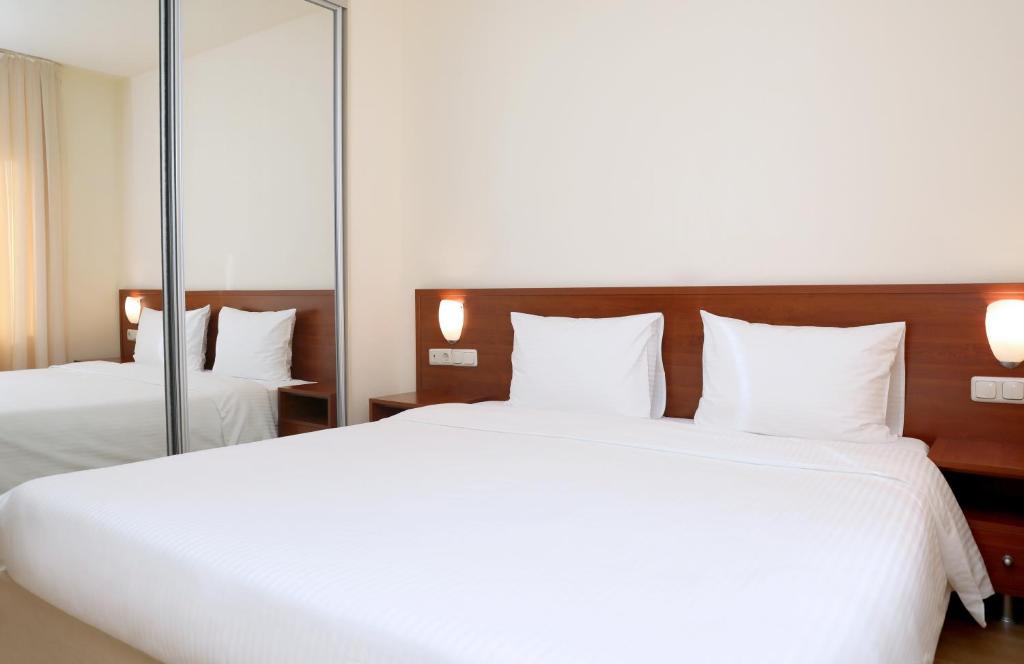 1 dormitorio con 2 camas y un espejo grande en Park Resort Aghveran, en Agveran