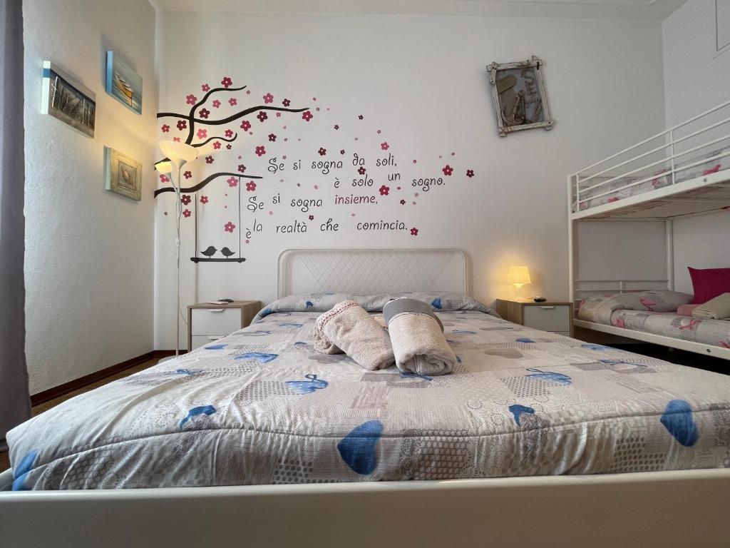 a bedroom with a bed with a tree on the wall at Le Palme 98 "Casa Vacanze" in Lido di Camaiore