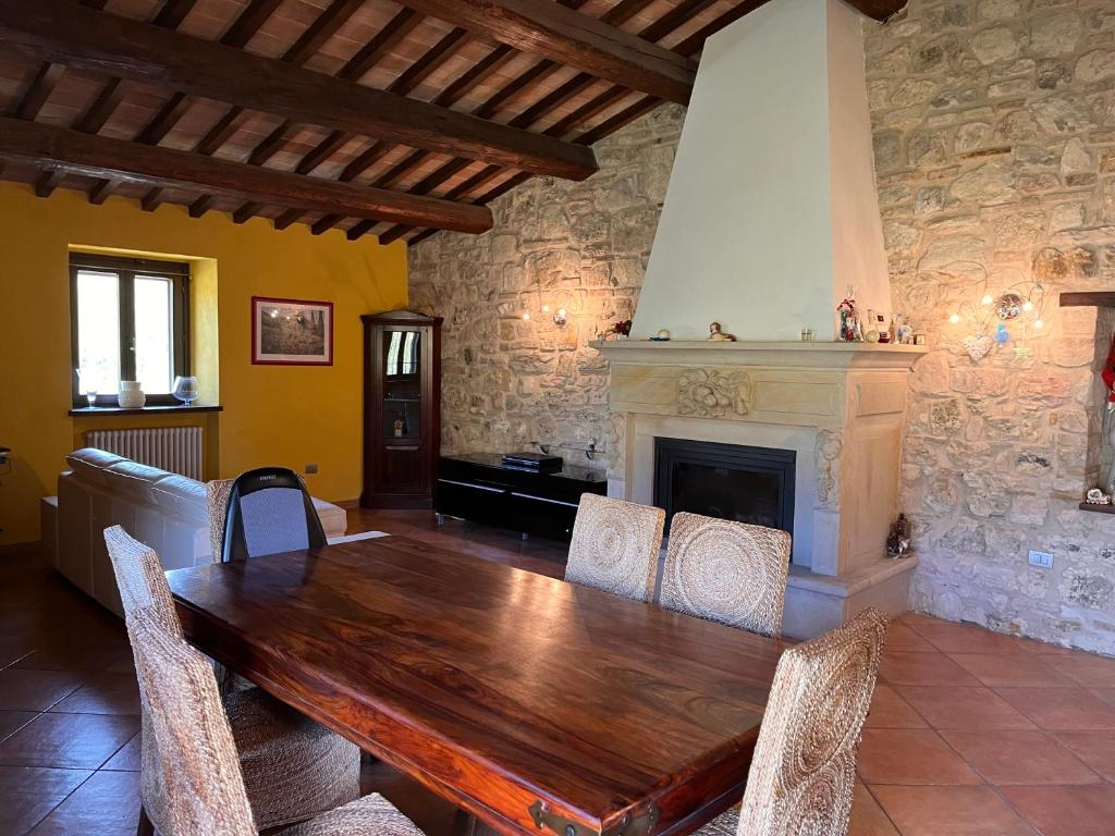 una sala da pranzo con tavolo in legno e camino di Agriturismo Ca'Verdeselle a Fermignano