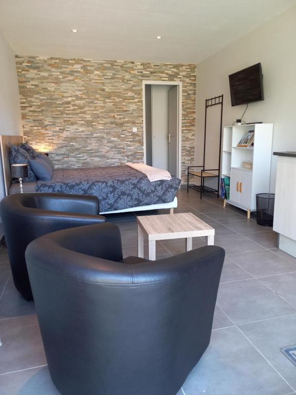 Montmorency-Beaufort"Le Studio" climatisation Parking Privé Restauration Proche des lacs的一间卧室，里面有一张床、一张沙发和一张桌子