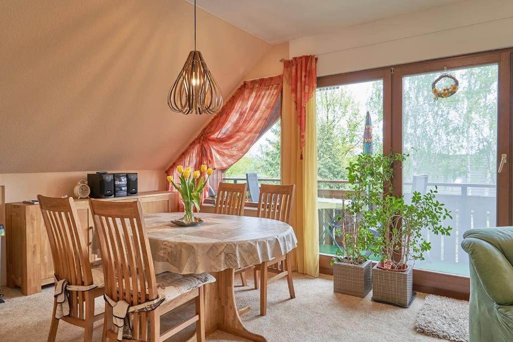 a dining room with a table and chairs and a window at Ferienwohnung am Stadtrand von Berlin in Neu Buch
