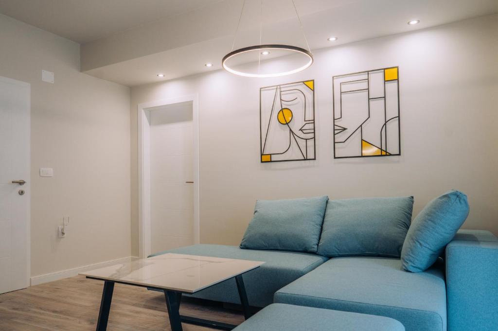 uma sala de estar com um sofá azul e uma mesa em Bellissimo Apartments em Ohrid