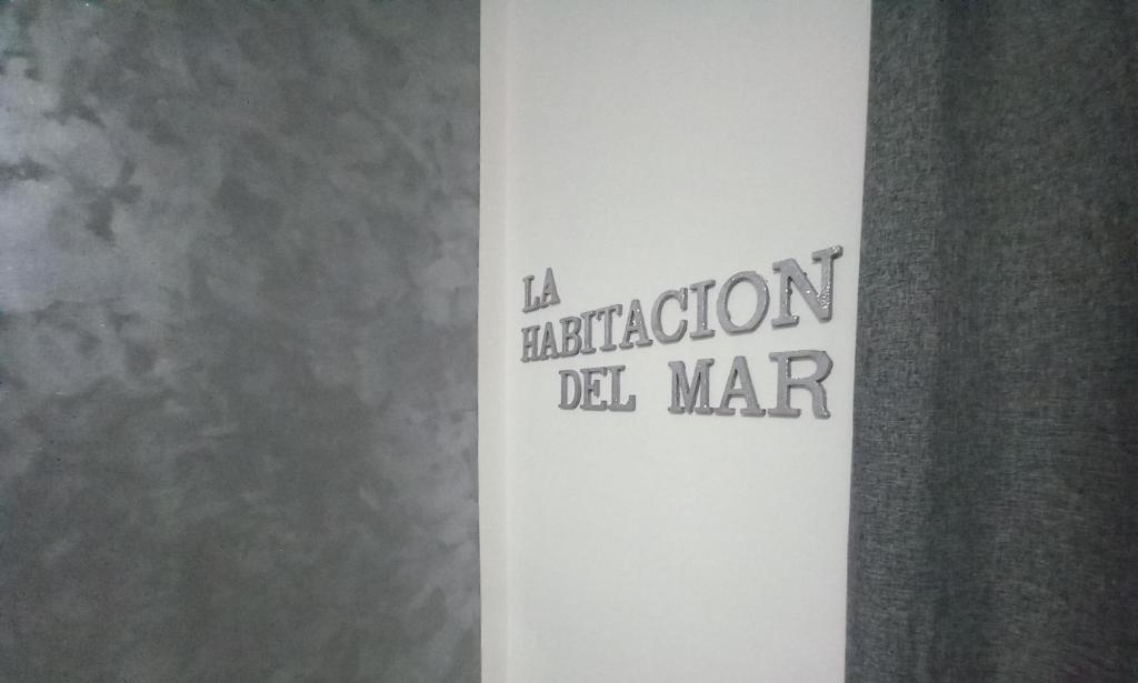 eine weiße Wand mit einem Schild, das eine Reflexion del Mar liest in der Unterkunft La Habitacion del Mar in Gallipoli