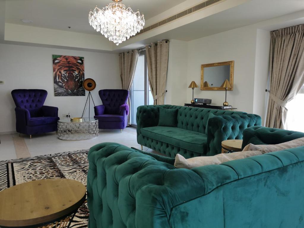 - un salon avec des canapés verts et des chaises violettes dans l'établissement Serenity 3BR Palm view in Marina, à Dubaï