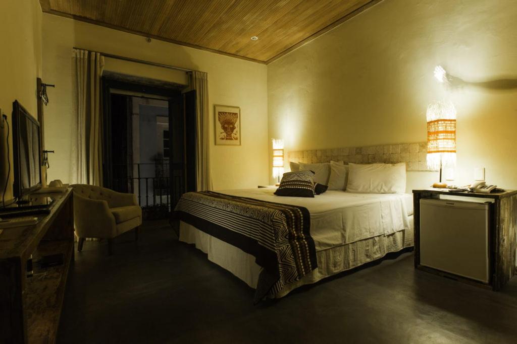 - une chambre avec un lit et un bureau avec une lampe dans l'établissement Bahiacafé Hotel, à Salvador