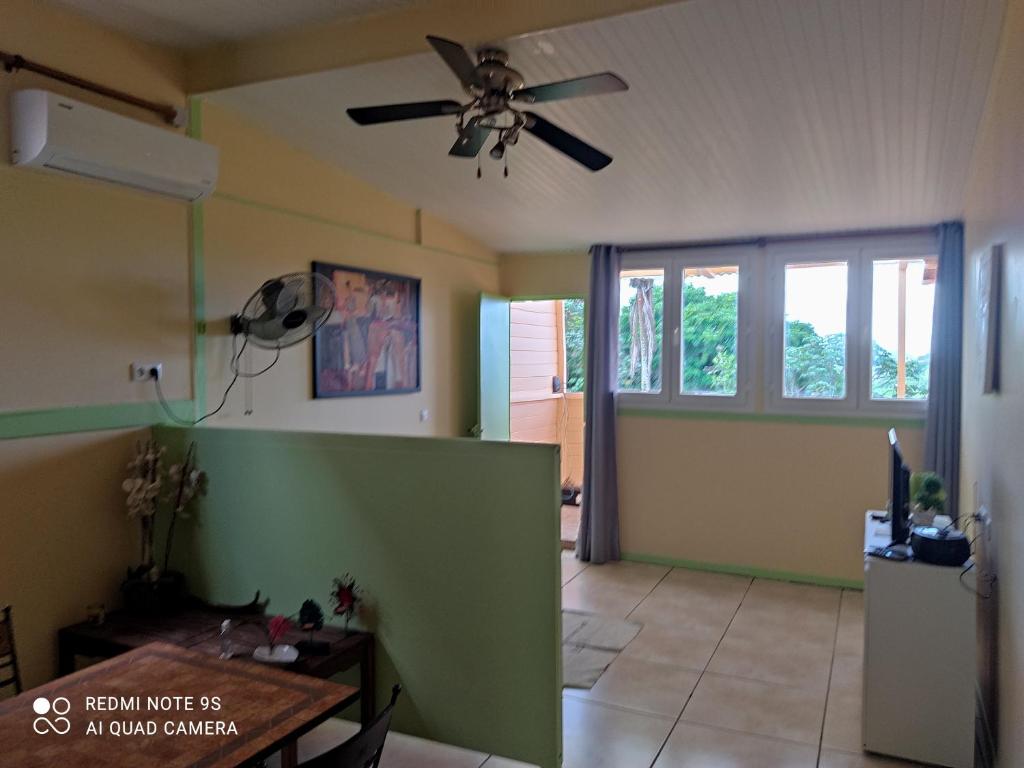 een woonkamer met een plafondventilator en een tafel bij Anajodrey in Saint-Joseph