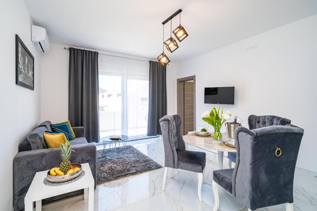 a living room with a table and chairs and a dining room at Apartment Olive in Dubrovnik
