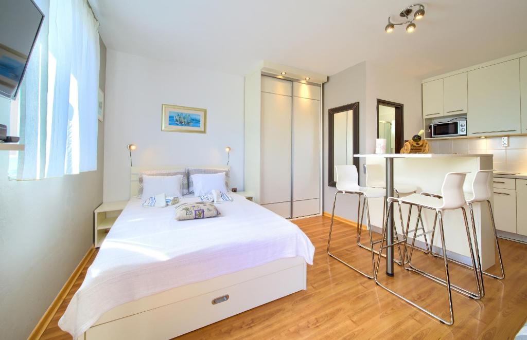 1 Schlafzimmer mit einem weißen Bett und einer Küche in der Unterkunft Studio Apartment Vesna in Krk