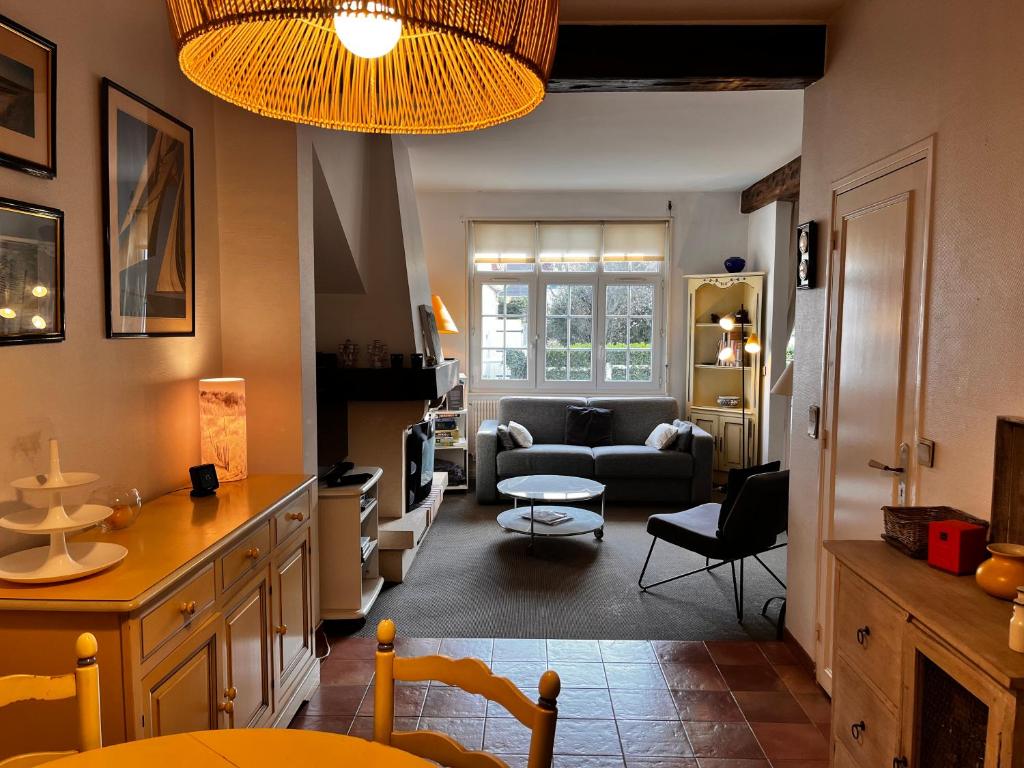 uma sala de estar com um sofá e uma mesa em Maison Cosy Touquettoise em Le Touquet-Paris-Plage