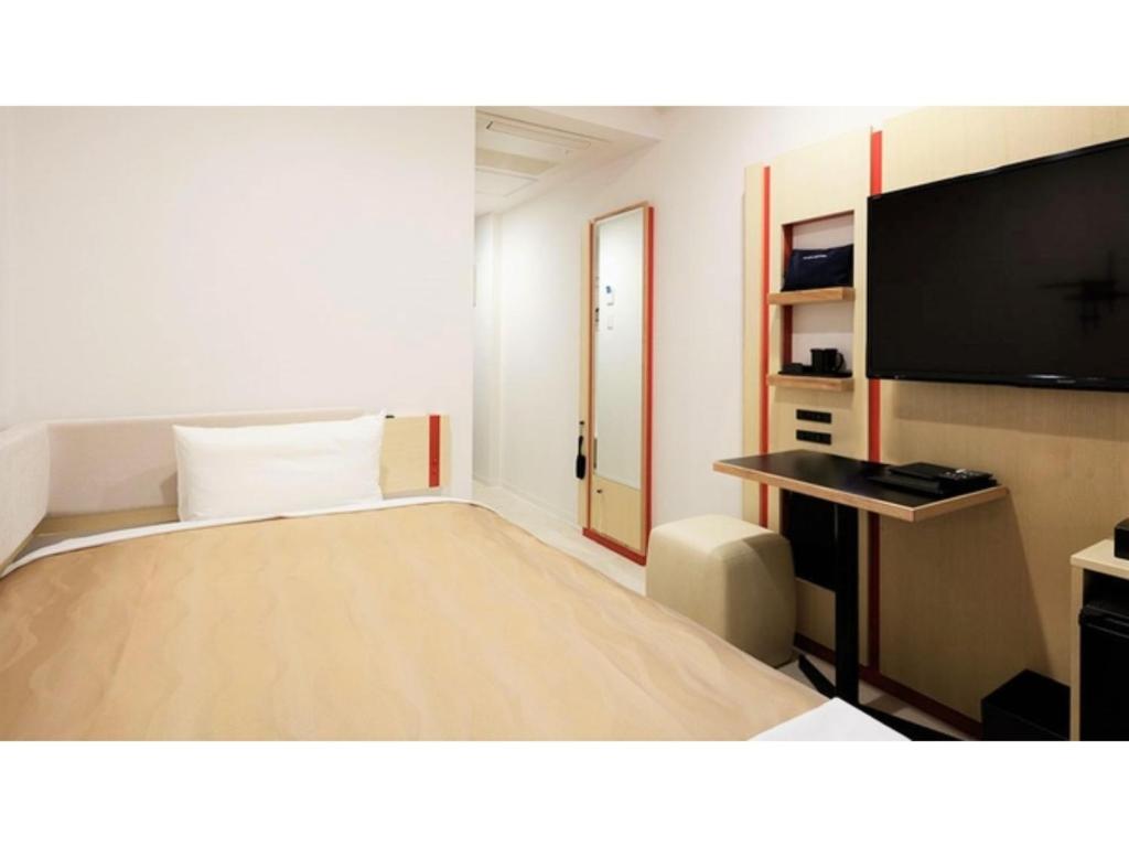 a hotel room with a bed and a flat screen tv at Center Hotel Narita 2 R51 - Vacation STAY 43389v in Narita