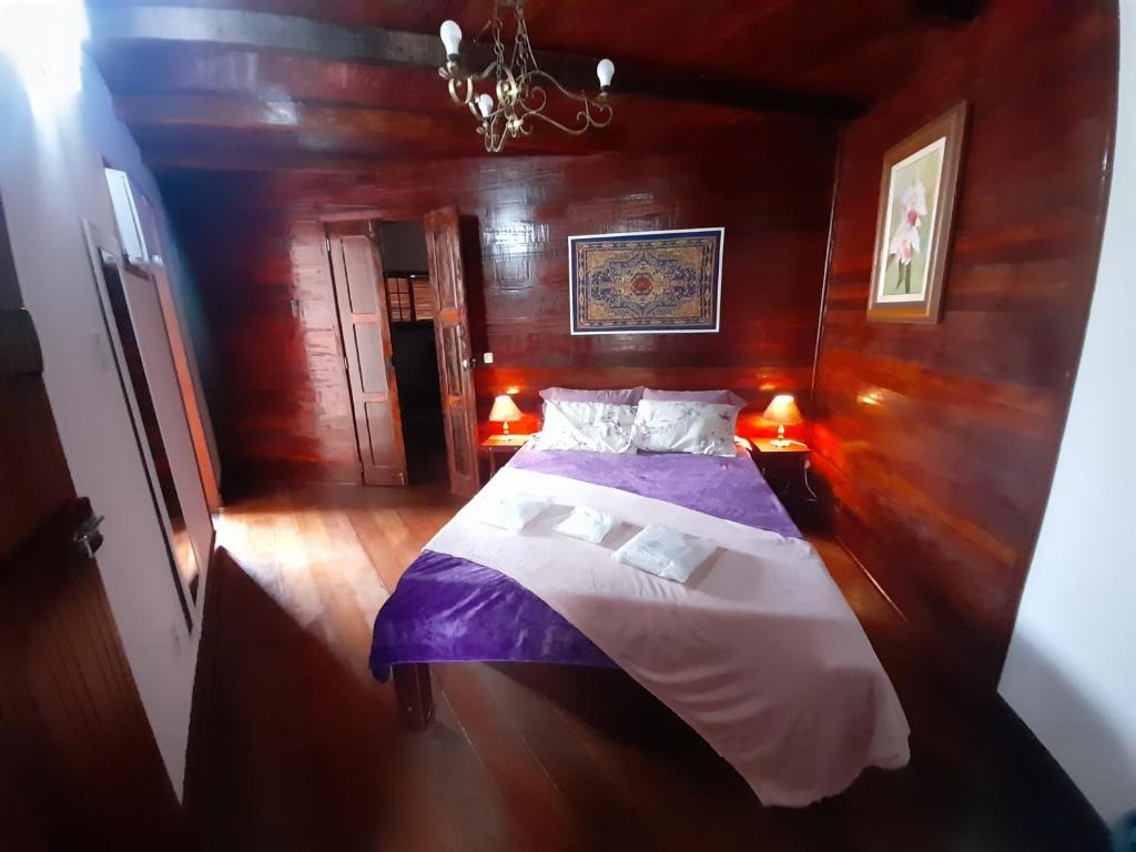 um quarto com uma cama num quarto de madeira em POUSADA BEIRUTE em Cabo Frio