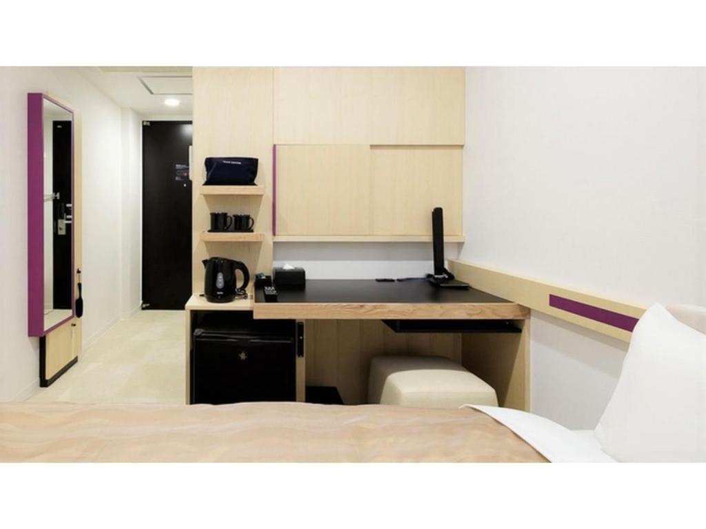Center Hotel Narita 2 R51 - Vacation STAY 43391v في ناريتا: غرفة بسرير ومكتب في غرفة