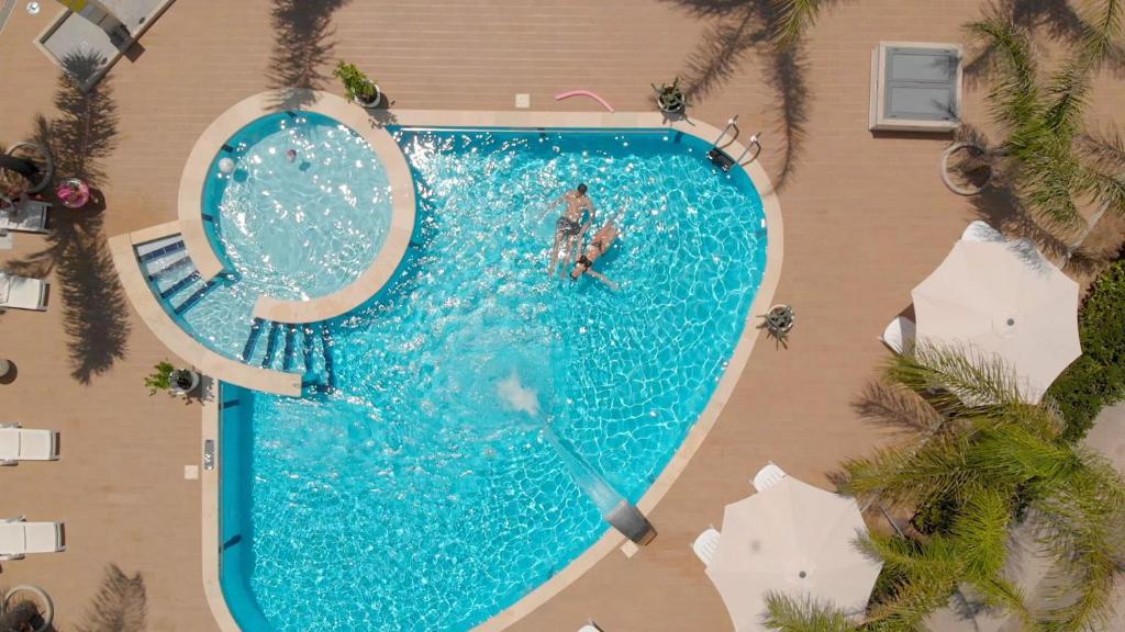una vista aérea de una piscina con una persona en el agua en ATTICO VISTA MARE E PISCINA, en Santa Maria del Focallo