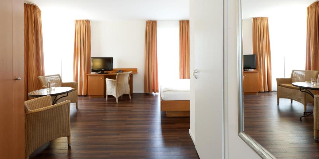 pokój hotelowy z łóżkiem, stołem i krzesłami w obiekcie Hotel Ambiente w Dortmundzie