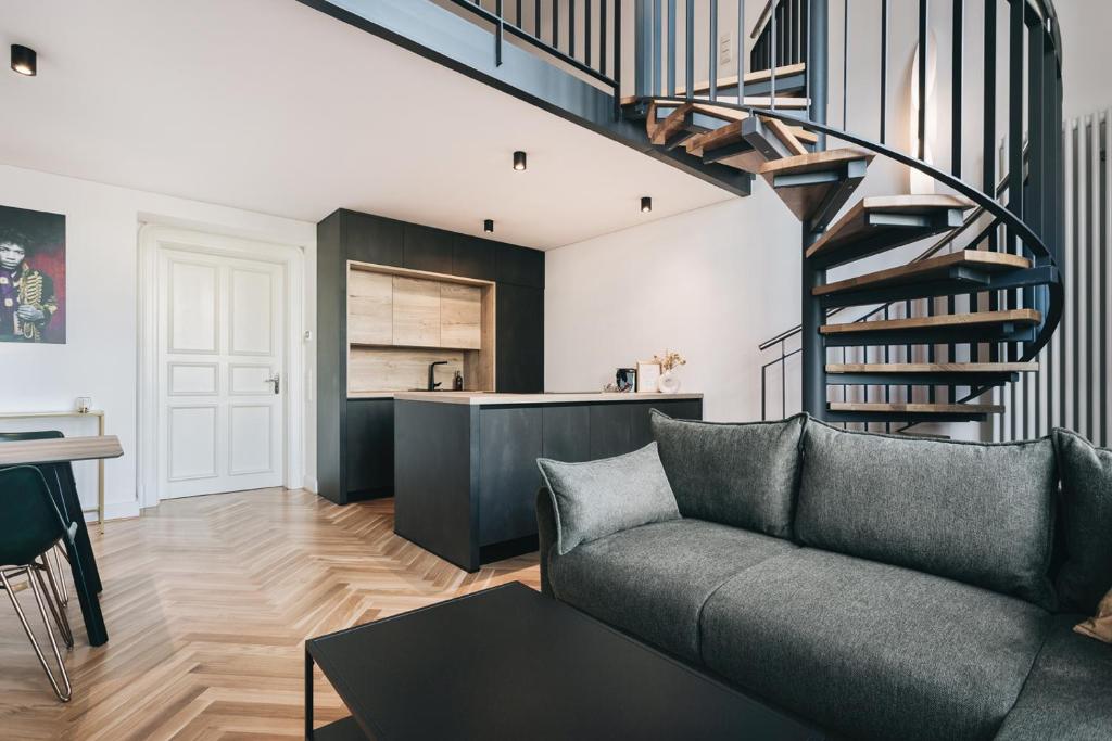 a living room with a couch and a spiral staircase at Palais Apartment direkt im Zentrum, FEWO-Residenz-Dresden in Dresden