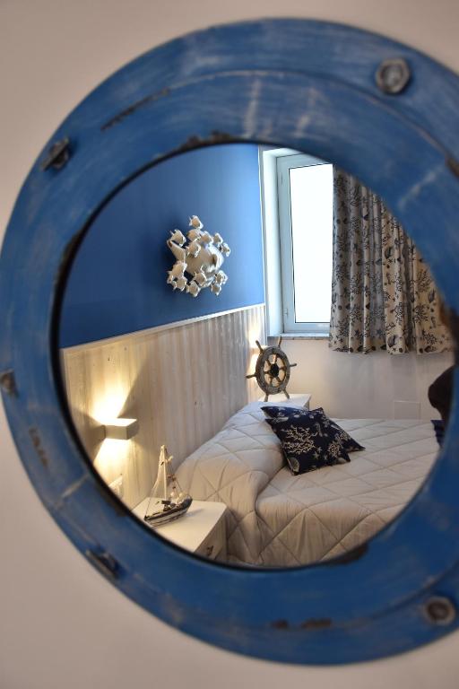 a bedroom with a bed and a mirror at B&B Marina Blu in Giardini Naxos