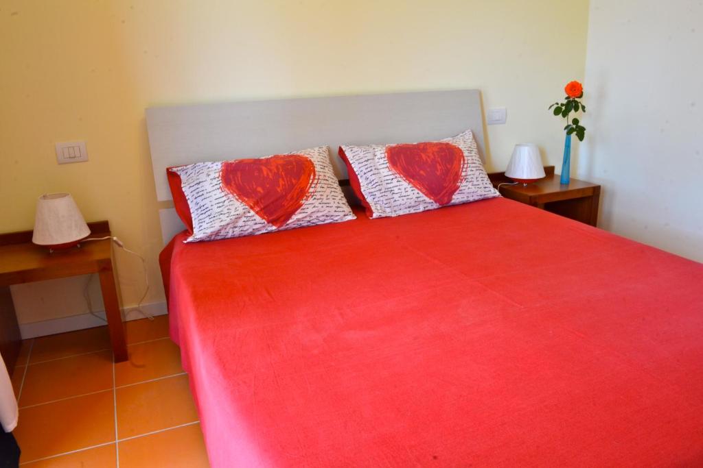 a bedroom with a red bed with two red pillows at B&B Sotto le Stelle in Fano