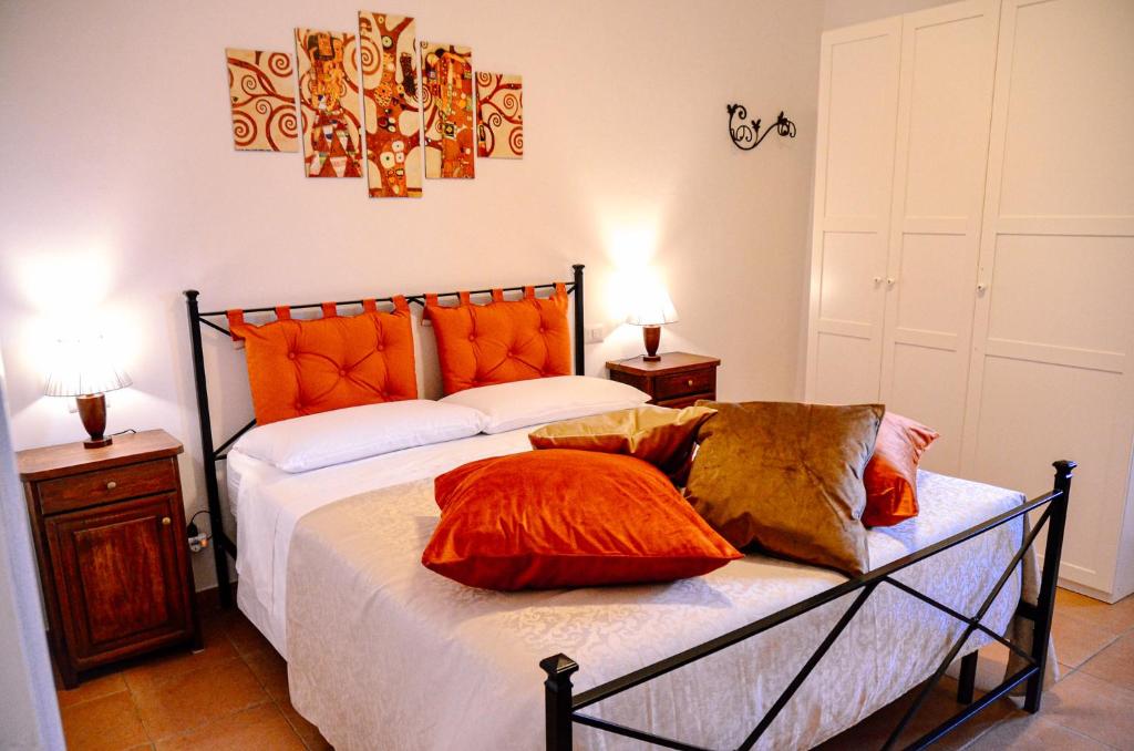 - une chambre dotée d'un lit avec des oreillers orange dans l'établissement Casetta sulla Vallata, à Pitigliano