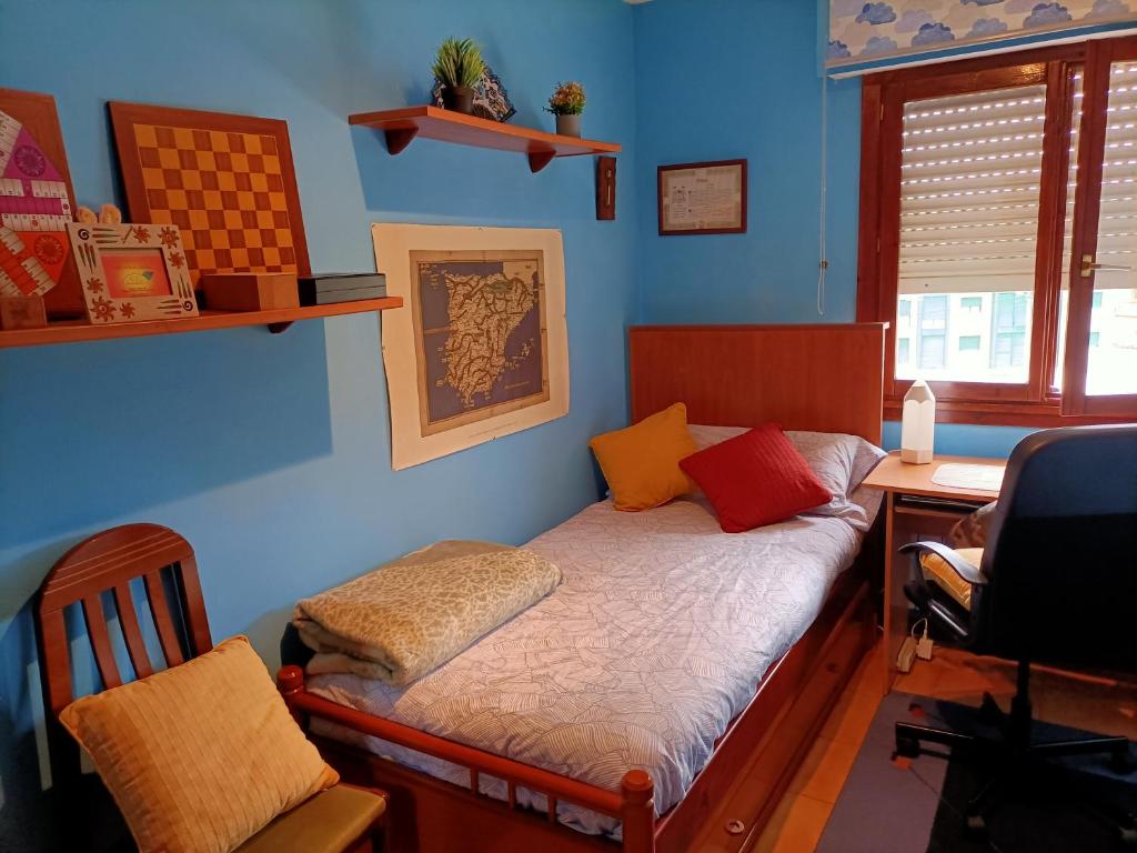 a bedroom with a bed with a desk and a chair at Hospedaje La Ijana in Bádames