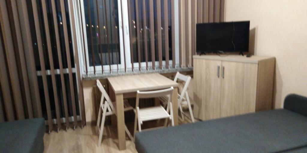 una camera con tavolo, sedie e televisore di Queens house a Oświęcim