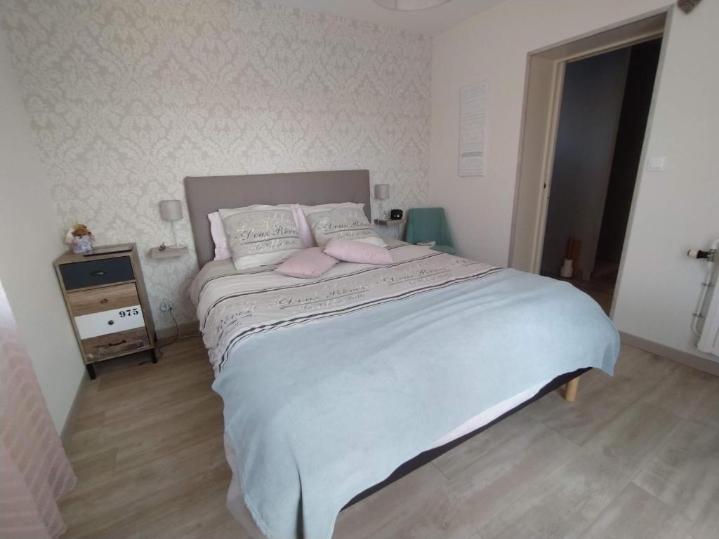 a bedroom with a large bed with pink pillows at Chambre entre mer et campagne in Gréville-Hague