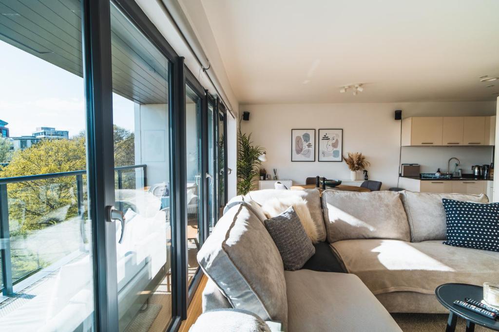 a living room with a couch and a large window at ⭑ Modern Town Centre Apartment ⭑ in Bournemouth