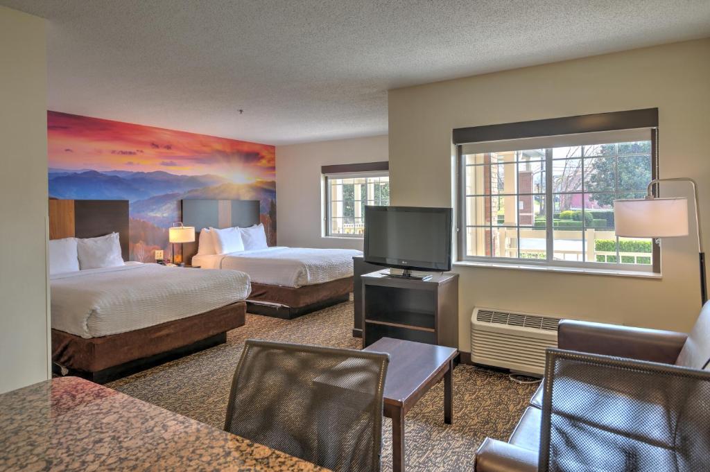 a hotel room with two beds and a flat screen tv at LeConte Hotel & Convention Center, Ascend Hotel Collection in Pigeon Forge
