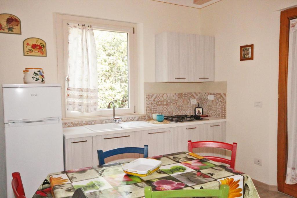 Appartamento Il Mandorlo في كابوليفيري: مطبخ مع طاولة ومغسلة وثلاجة