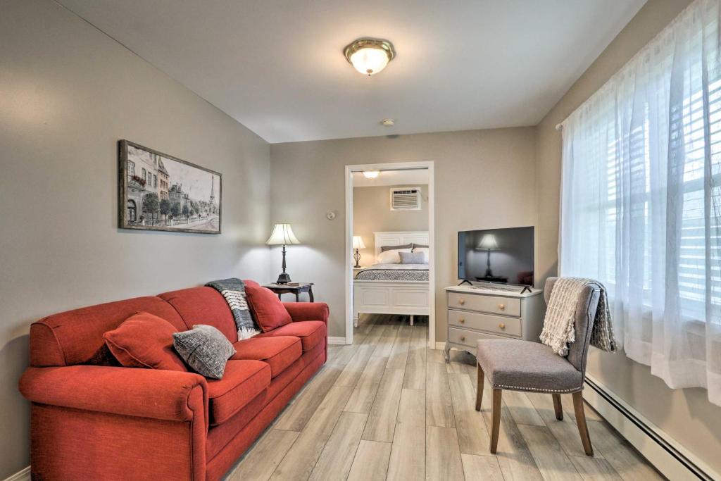 a living room with a red couch and a bedroom at Centrally Located South Hill Apartment with Smart TV in Spokane
