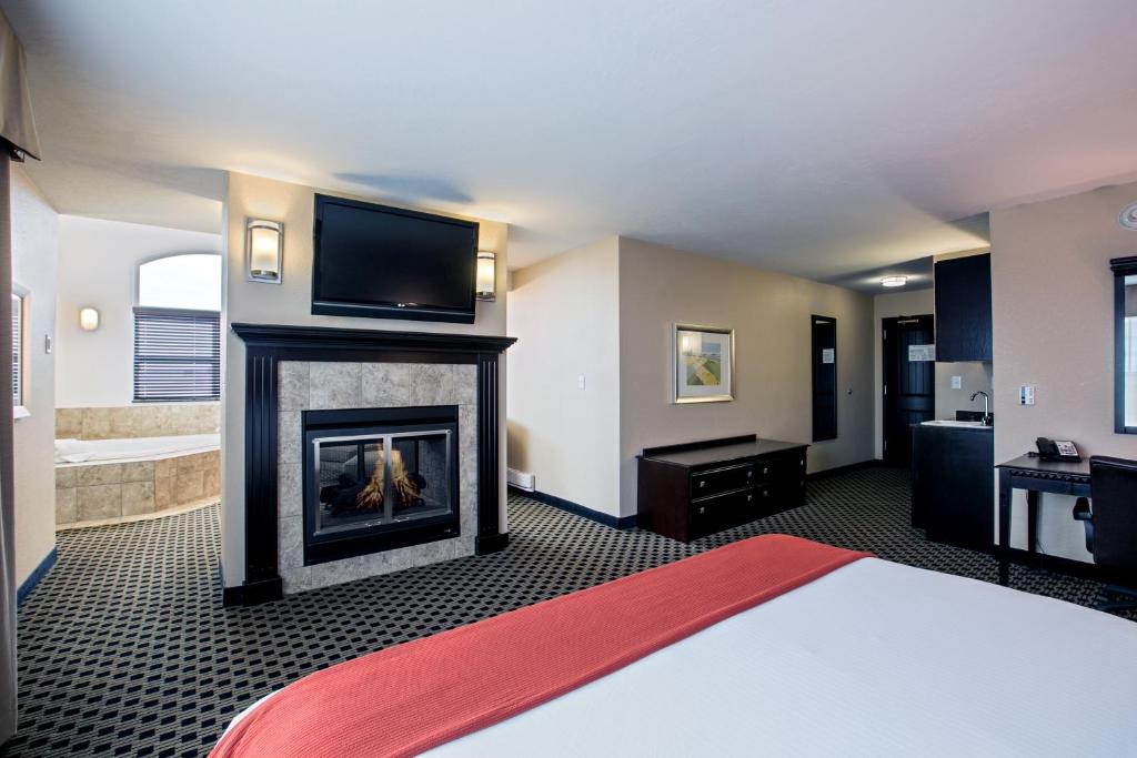 a room with a fireplace with a tv above it at Holiday Inn Express & Suites - Green Bay East by IHG in Green Bay