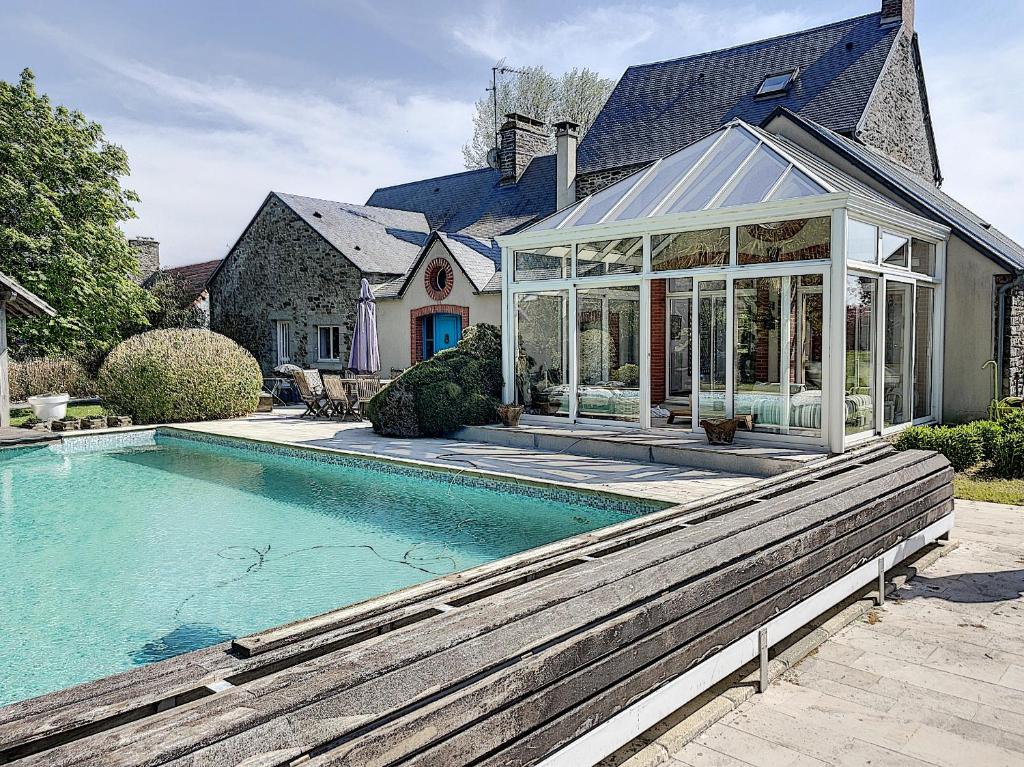 a house with a conservatory and a swimming pool at Gîte de charme "La Maison Saint-Leonard" avec piscine, SPA, vue sur le Mont Saint-Michel in Vains