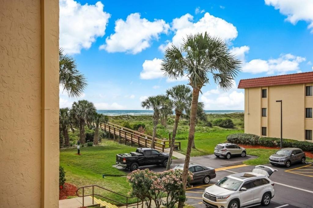 a view from a window of a parking lot with palm trees at St, Augustine Ocean and Racquet 5218 condo in Saint Augustine