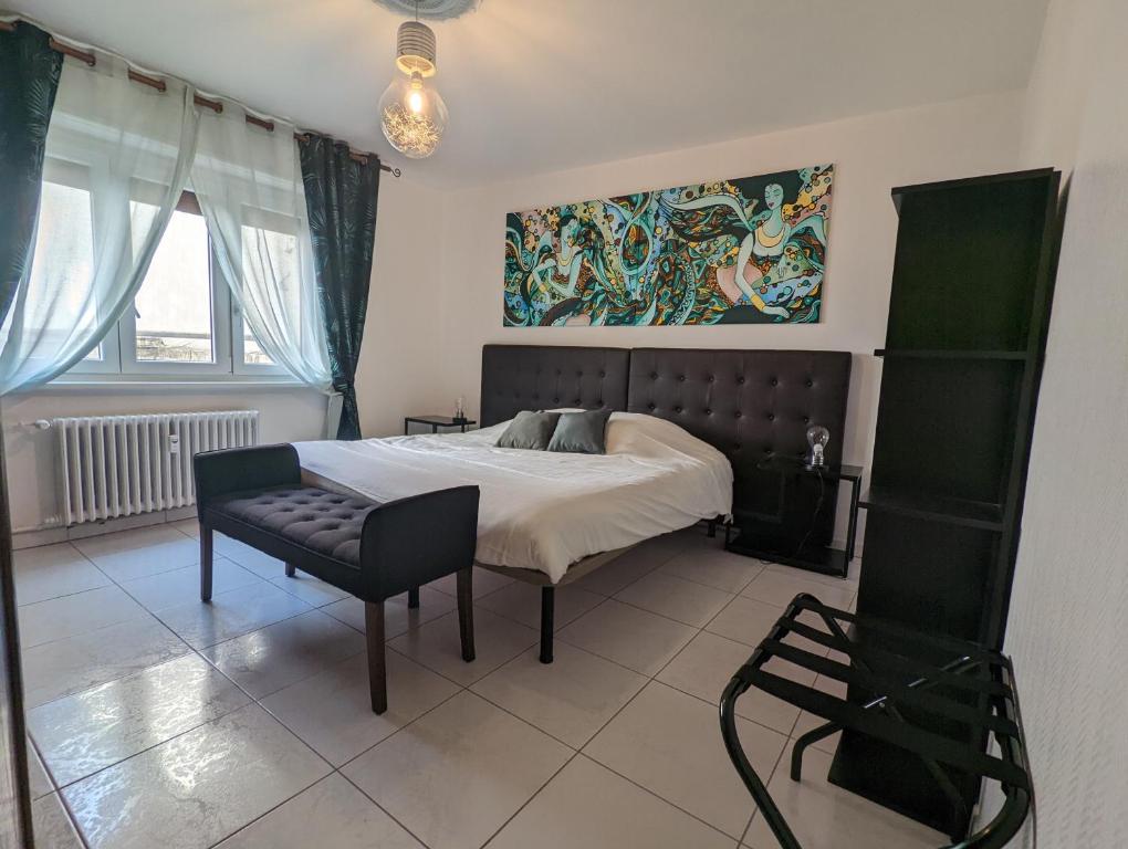 - une chambre avec un lit, une chaise et un tableau dans l'établissement CityCosy Strasbourg - Art Style, à Strasbourg