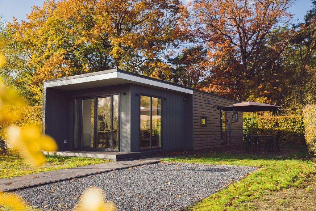 a black tiny house with a garden at Tiny Cabin with Hottub I 4 p in Rijssen