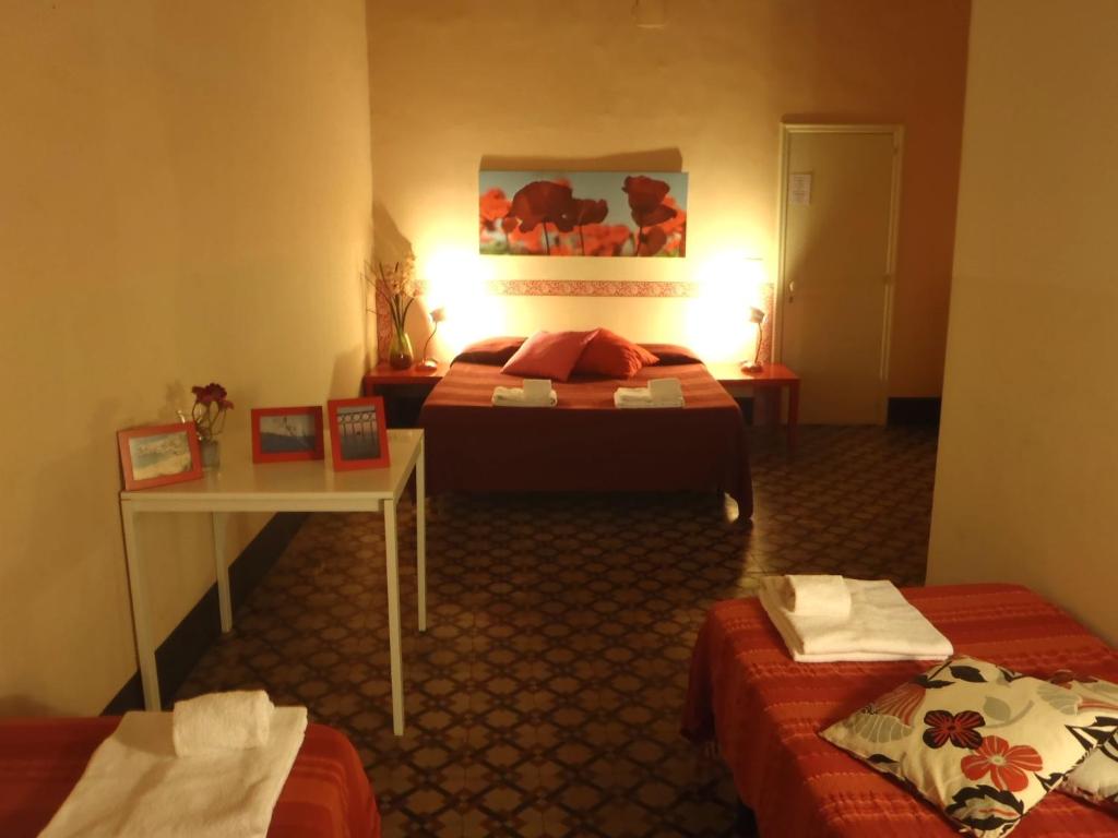 a hotel room with two beds and a table at Gianluca's Room in Catania