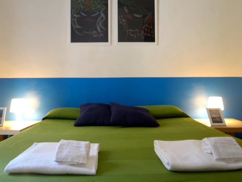 zielone łóżko z dwoma ręcznikami na górze w obiekcie Gianluca's Room w Katanii