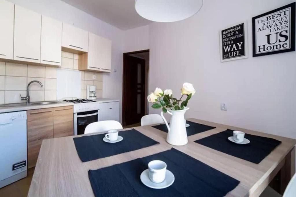 kuchnia ze stołem z krzesłami i wazonem kwiatów w obiekcie Urban Nest Apartments Szewska 21-19 w Krakowie