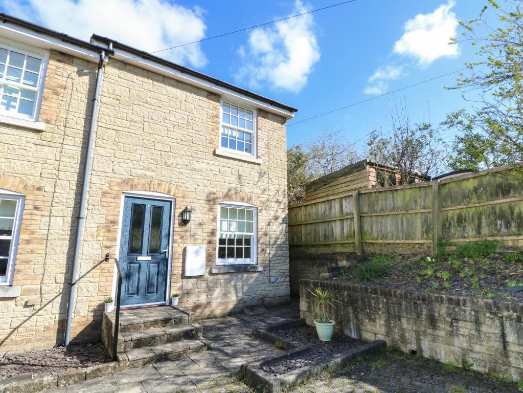 an old brick house with a fence at 4 The Old Post Office Mews in Brading