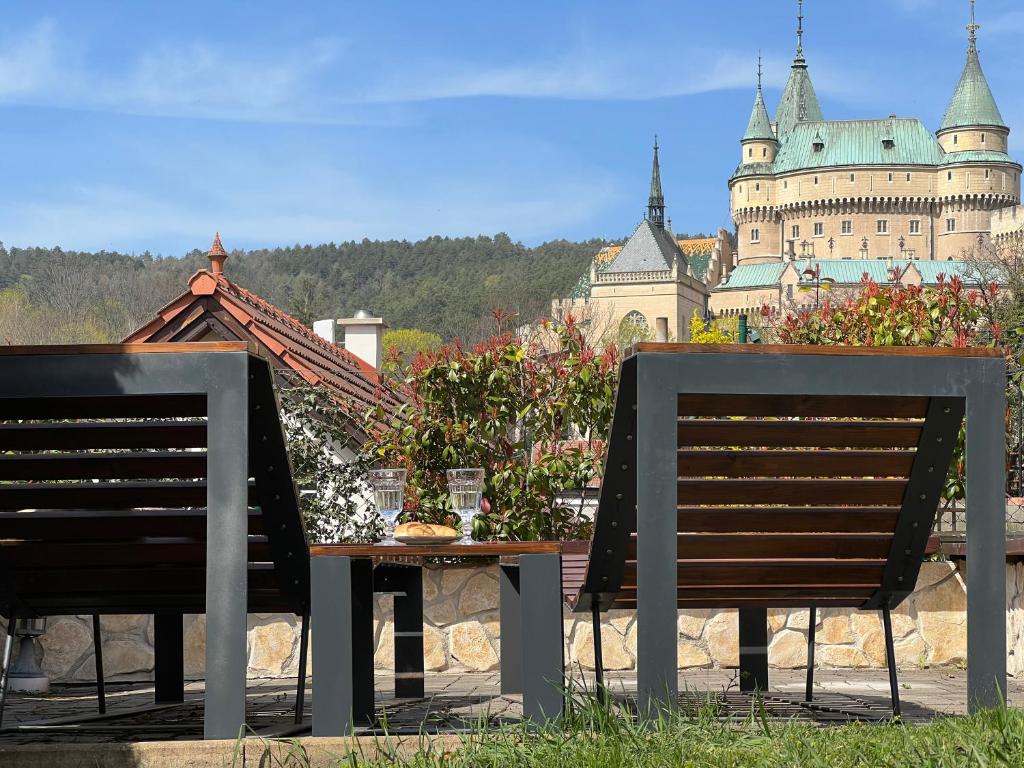 a table and chairs with a castle in the background at Apartments Hradný Mur in Bojnice