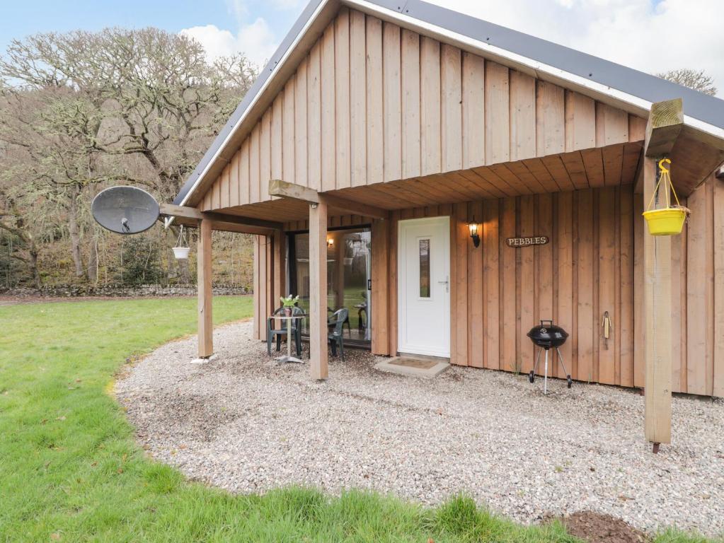 a barn with a porch and a grill at Pebbles Cottage in Contin