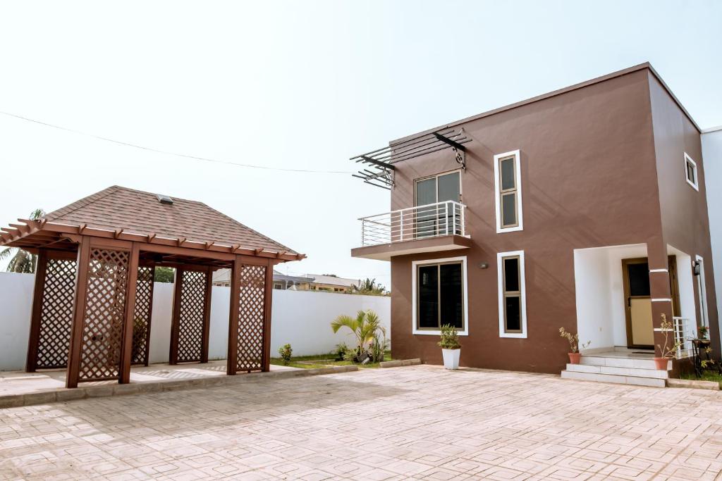 una casa con un cenador frente a ella en Baldwin Beauty House, en Accra