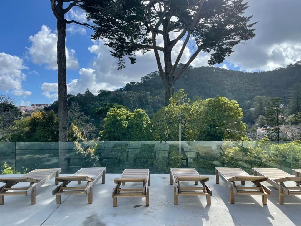 um grupo de mesas de piquenique e cadeiras num pátio em Cedros Nature House em Sintra