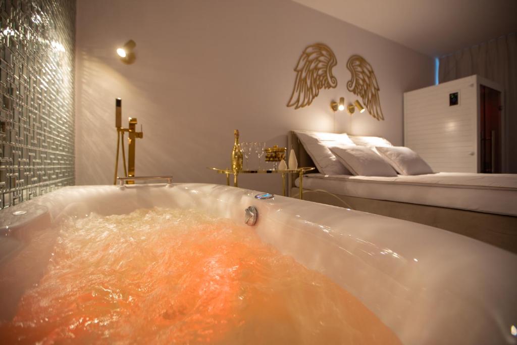 科沃布熱格的住宿－Apartament Gold SAUNA&JACUZZI Kołobrzeg，浴缸里装满了橙色液体
