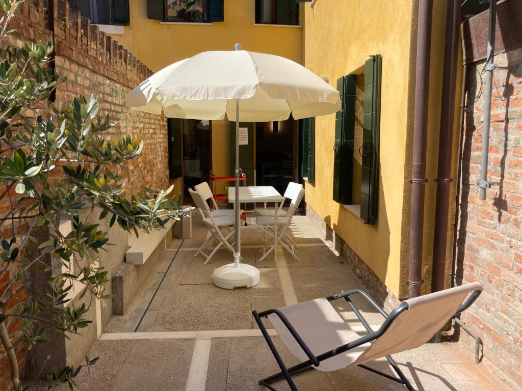 a patio with a table and chairs and an umbrella at Appartamento Tre Archi con corte privata in Venice