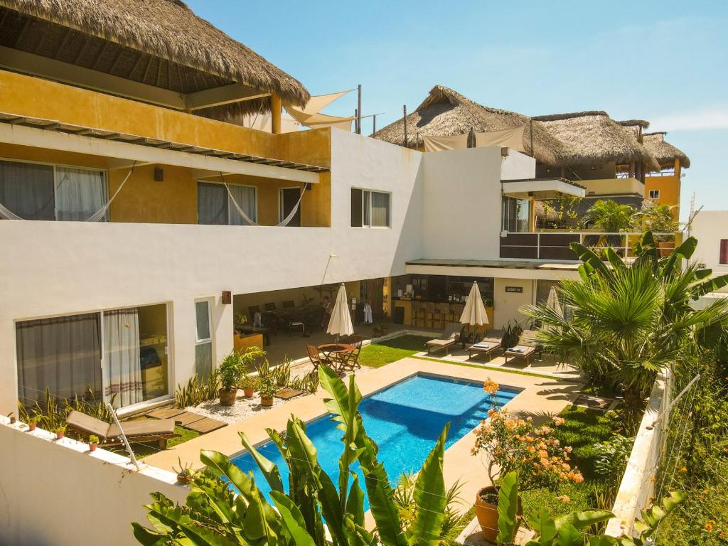 a large white building with a pool of water in front of it at Villa Bonobo in Puerto Escondido