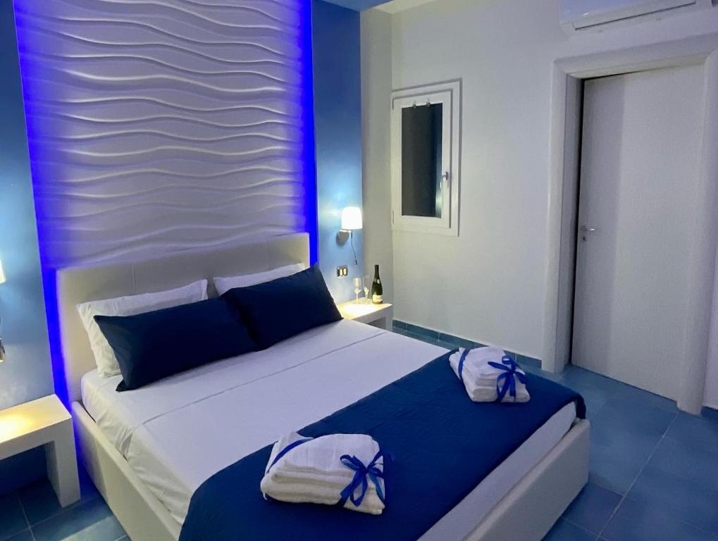 um quarto com uma cama grande com arcos roxos em Salento Sottovento Luxury BeB em Torre Lapillo