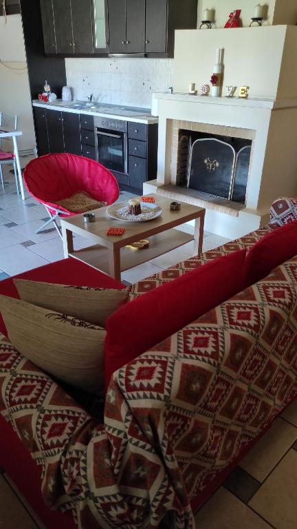 een woonkamer met een bank, een tafel en een open haard bij ERMONES LITTLE HOUSE in Vátos