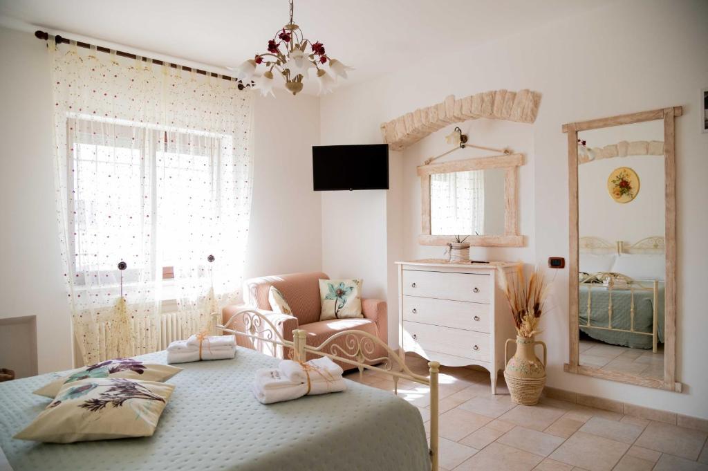 a bedroom with a bed and a chair and a dresser at Dimora Aia Piccola in Alberobello